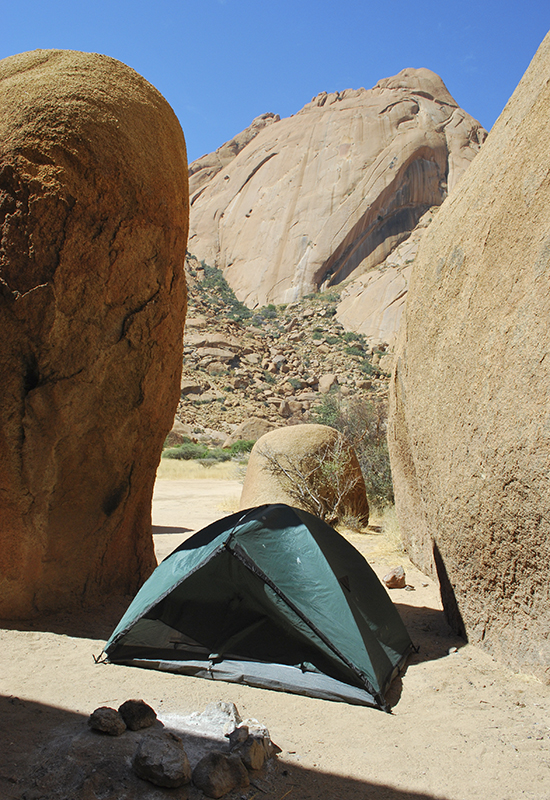 camping tent behind a boulder