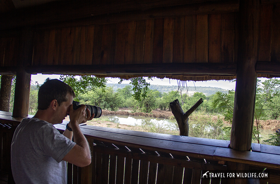 photographer at a bird hide overlooking a waterhole