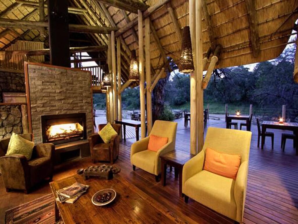 safari lodge lounge with fireplace and views to the dry riverbed