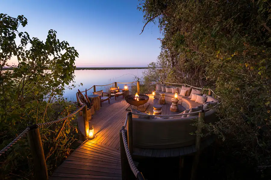 Campfire and boma on a wooden platform above a river